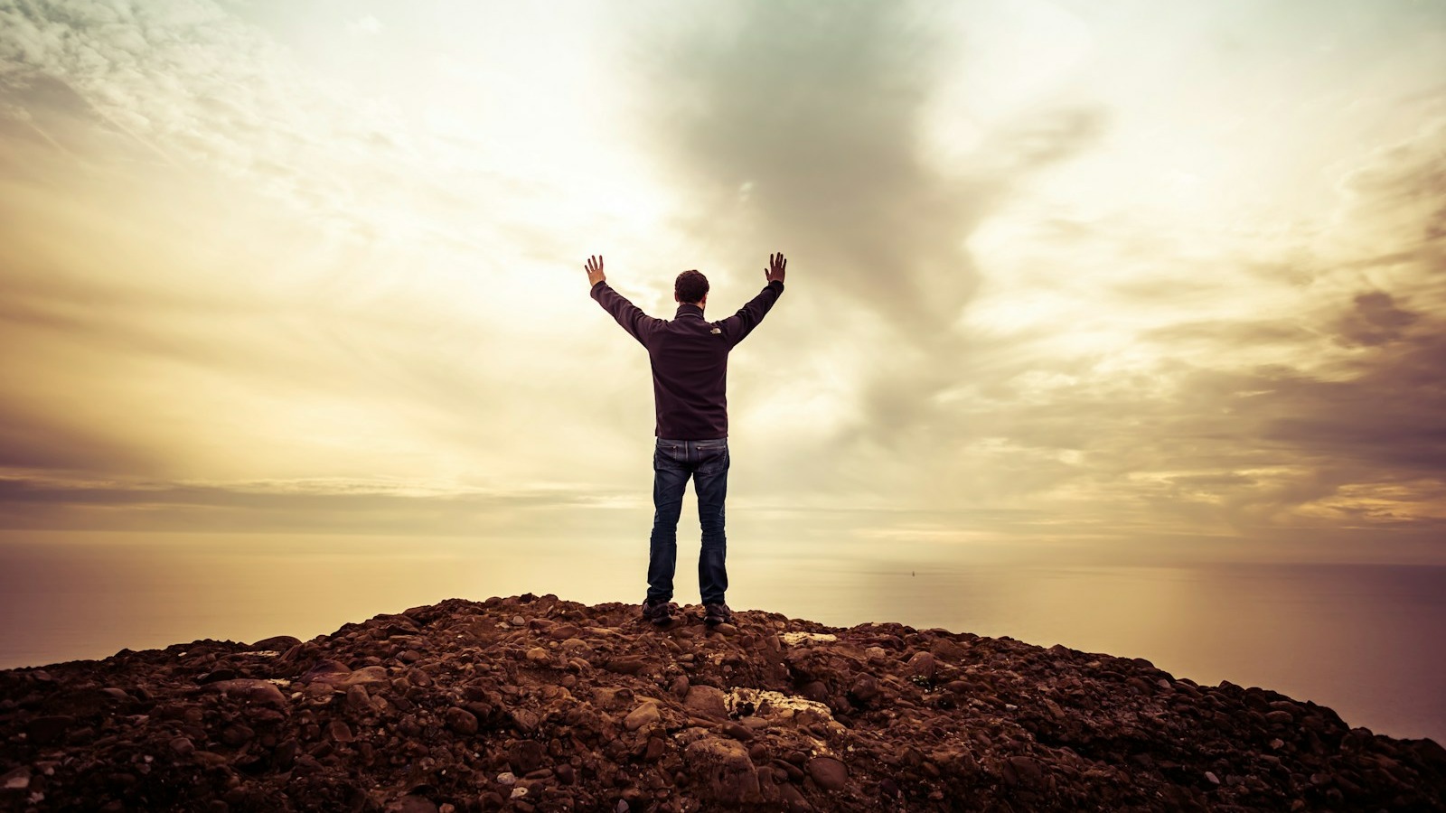 man standing under orange sky
